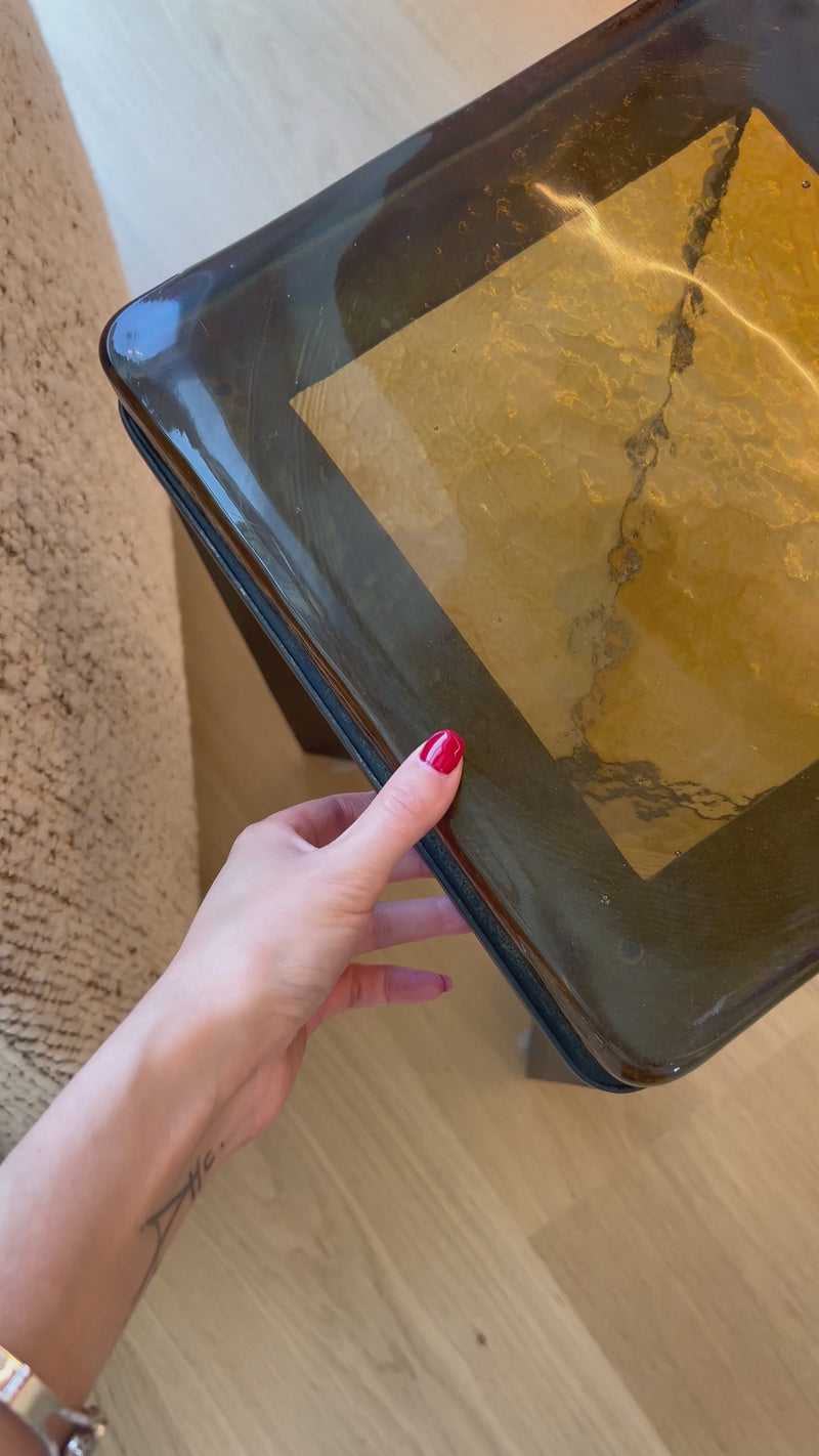 An airy, angular base of charcoal-burnished iron supports a squared tabletop of amber cast glass, perfectly sized to keep your drink or book within reach.Overall Dimensions: 12.50"w x 12.50"d x 22.00"hWeight : 36.38 lbsMaterials : Cast Glass, Iron Amethyst Home provides interior design, new home construction design consulting, vintage area rugs, and lighting in the Monterey metro area.