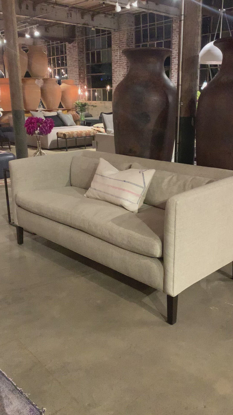The Stewart Sofa by Cisco Brothers has a simple silhouette with striking angles and trim wooden accent legs. The wide bench cushion provides ample seating space ideal for entertaining. Pop some popcorn and pile on the throw pillows for cozy movie nights with the family. Photographed in Vintage Flax. Lifestyle Shot in Brevard Burlap. Amethyst Home provides interior design, new home construction design consulting, vintage area rugs, and lighting in the Park City metro area.