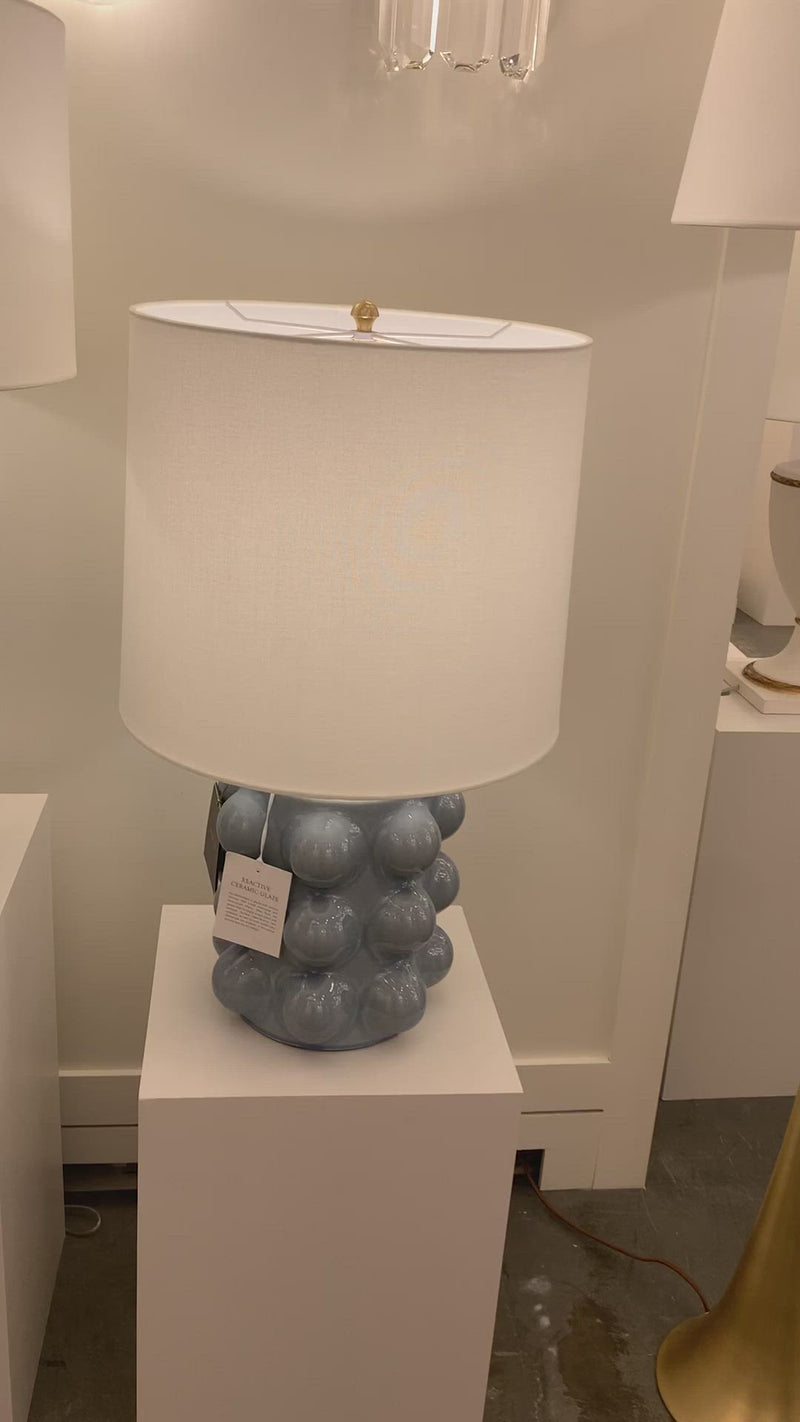 We love the form shape of this Vedra Medium Table Lamp. The dimmer feature makes it a perfect choice for your bedroom, living room, or other area that is perfect for setting the mood.   Reactive Ceramic Glazes Will Vary in Color and Texture  Designer: AERIN